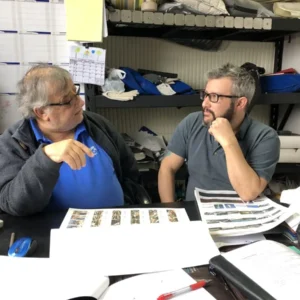 Rencontre entre Jean-Pierre et Éric Marchand dans l’atelier Redecor Plus, entourés de plans et d’échantillons de tissus