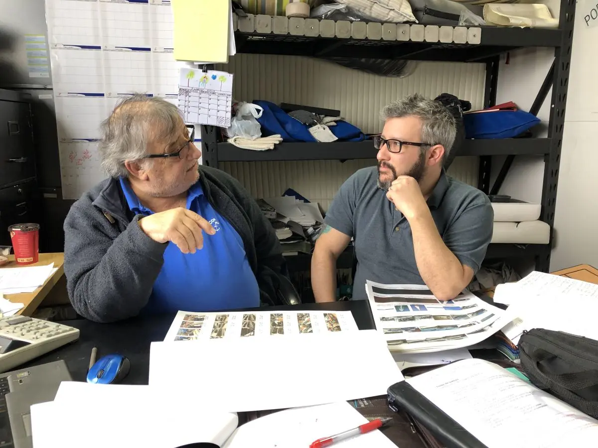 Rencontre entre Jean-Pierre et Éric Marchand dans l’atelier Redecor Plus, entourés de plans et d’échantillons de tissus