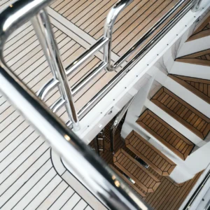 Revêtement de plancher marin en bois synthétique sur un bateau de luxe, incluant des escaliers et des surfaces antidérapantes.